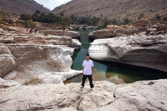 Man standing at a rock pool in Wadi Bani Khalid