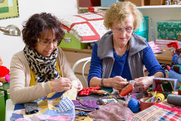 two women working on their quilting - obrazy, fototapety, plakaty