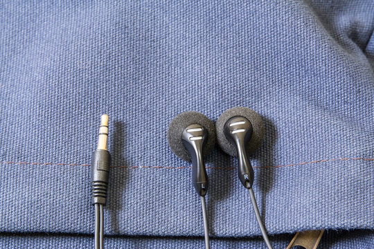 Black Earbud On Blue Canvas Bag