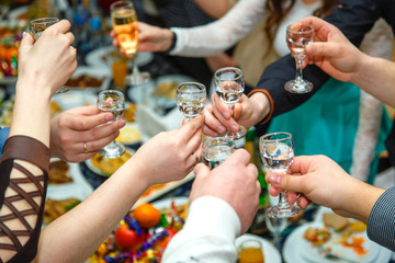 People hands Clinking glasses with vodka and wine - obrazy, fototapety, plakaty