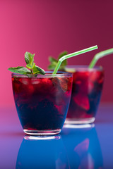 Raspberry and blackberry cocktail with mint garnish. Studio shot