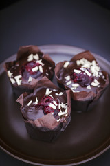 Closeup of delicious muffins on a brown plate.