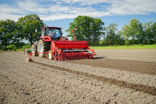 Roter Schlepper mit S&auml;maschine von hinten fotografiert