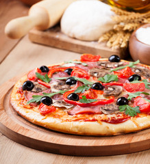 Tasty pizza and fresh ingredients on the table