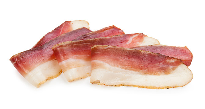 Slices of tasty spanish ham on white background