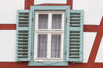 Fototapeta premium Altes Haus mit rotem Fachwek und grünem Fenster