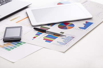 Market. Financial charts on the table with tablet  phone and pen
