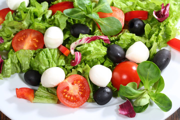 Fototapeta na wymiar Salad with a mozzarella, tomatoes, olives, salad