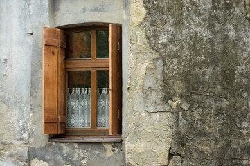 Window frame with the old shutters on the stonу wall