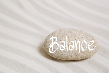 Wort Balance auf Stein im Sand als Hintergrund für Wellness