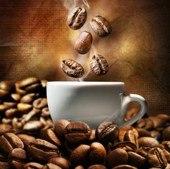 Obrazy  Filiżanka kawy z fasolą na ciemnym tle