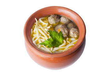 soup with pasta and meatballs in a clay pot