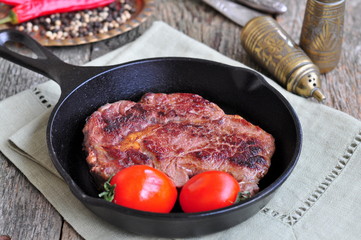 Juicy beef steak in a frying pan