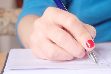 Female hand with pen and notebook
