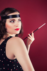 Obraz premium beautiful retro woman holding mouthpiece against wine red backgr