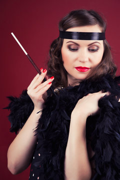 beautiful retro woman holding mouthpiece against wine red backgr