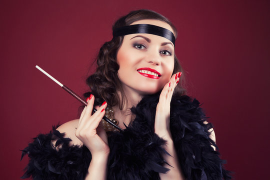beautiful retro woman holding mouthpiece against wine red backgr