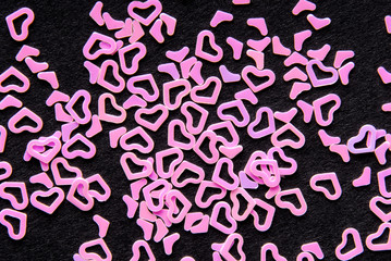 pink heart confetti on black background