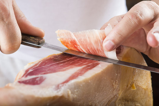 Profesional cortando lonchas de jam&oacute;n serrano a cuchillo