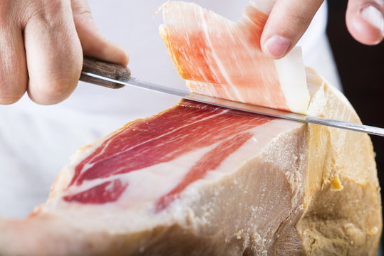 Profesional cortando lonchas de jam&oacute;n serrano a cuchillo