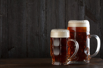 Beer glasses on table, dark wooden background with copy space