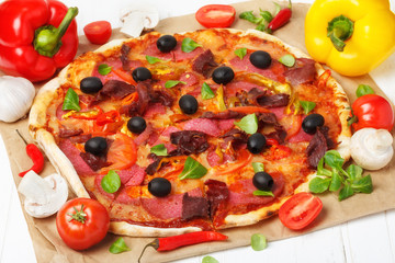 Hot pizza with ingredients on wooden table still life