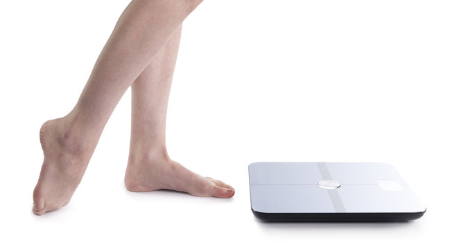 Bare Feet of a Woman Beside Body Analyzer Device