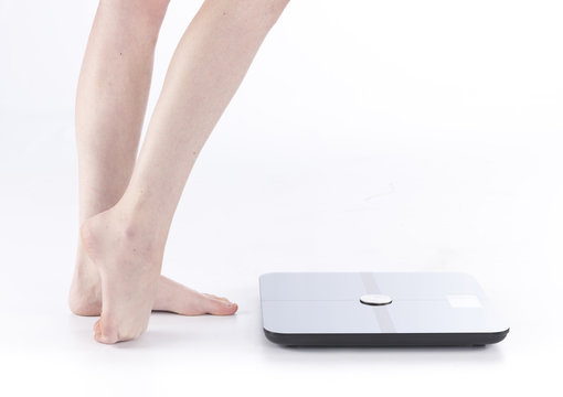 Female Feet and Legs Standing Near Weighing Scale