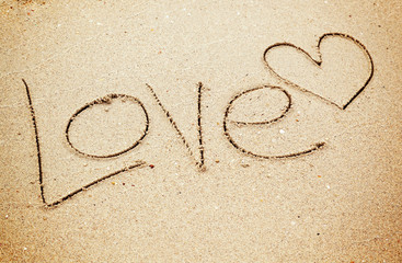 Love text and heart drawn on sand