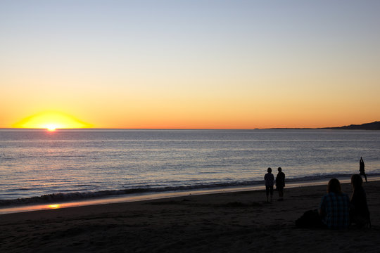 Sunet at beach with people watching © acfrank
