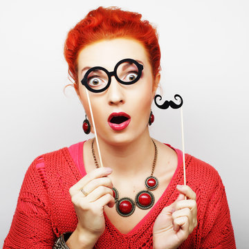 woman holding mustache and glasses on a stick.