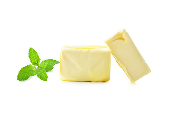 Stick of butter and mint leaves isolated on white.