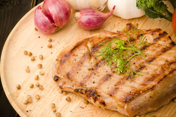 Grilled pork (pork steak) on wooden plate