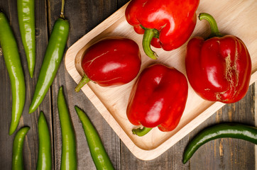 Fresh bell pepper and green pepper on wooden background