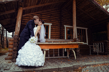 Beauty bride and elegant groom near old wood house