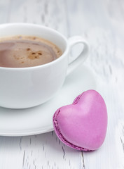 A cup of hot chocolate with a  heart-shaped macaron (vertical)