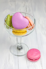 Colorful macarons in the glass on the wooden table