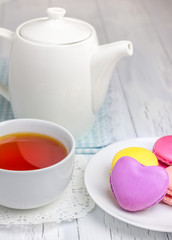 Obraz na płótnie Canvas A cup of tea with colorful macarons