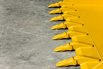Big yellow bucket scoop on rough concrete ground. © Paweł Michałowski