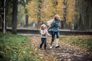 Naklejka na ściany i meble Mother with daughter in autumn park
