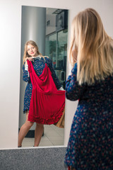 Woman trying red dress shopping for clothing.