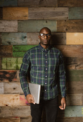 Obraz premium Portrait of serious young african man with a laptop