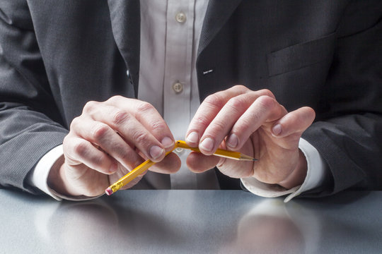 businessman breaking a pencil out of nervosity at the office