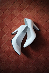 White shoes of bride on a brown rug