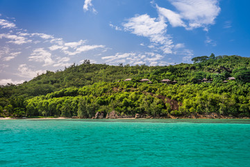 View of Seychelles coastline with houses in the forest