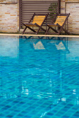Obraz premium Chair on ground beside swimming pool
