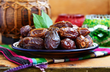 Dry dates on oriental ceramic plate with empty space