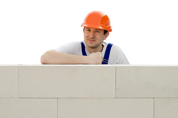 Builder erects a wall from a brick