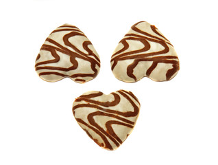 Three cookies, covered with whThree heart-shaped cookies covered