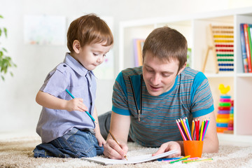 Obraz premium child and father drawing with colourful pencils